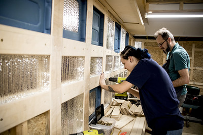 Woman using a drill working on Mars Mobile Habitat