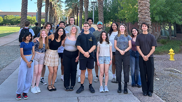 Group photo of student space ambassadors on a palm tree lined sidewalk.